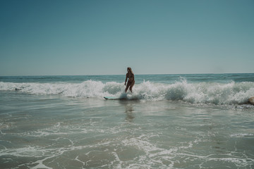 Chica joven y guapa surfeando por playas de Cadiz