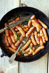 Selective focus. Fried sausages with a crispy crust. Beer snack. German spiced sausages in a frying pan.
