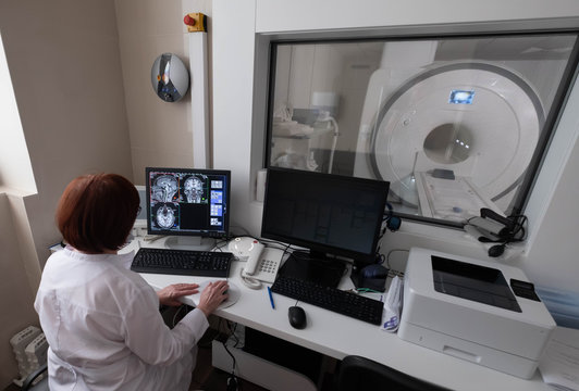 Professional Scientists Work in the Brain Research Laboratory. Neurologists Neuroscientists Surrounded by Monitors Showing CT, MRI Scans Having Discussions and Working on Personal Computers