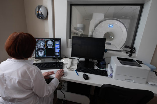 Professional Scientists Work in the Brain Research Laboratory. Neurologists Neuroscientists Surrounded by Monitors Showing CT, MRI Scans Having Discussions and Working on Personal Computers