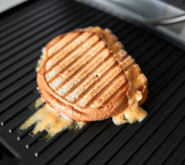 homemade panini with melted cheese on grill pan