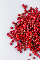 fragrant pink peppercorns on white acrylic background