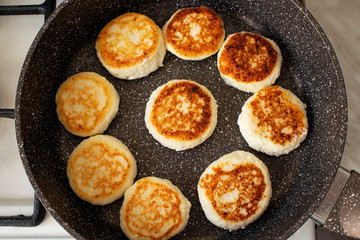 Cheese pancakes fried in a pan.
