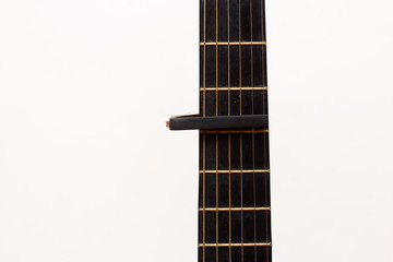 Cap on guitar fretboard on white background. Close plan. Wooden guitar.