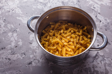 Traditional Italian pasta in a metal pan on a stone background