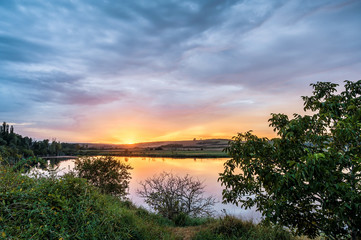 Ausblick über einem See zum Sonnenuntergang am Horizont