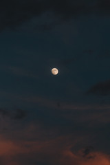 Obraz premium Moon in the sky during the evening besides clouds