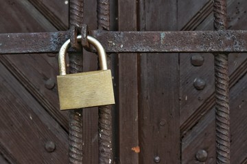 Padlock on rusty metal old grilles
