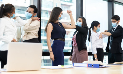 New normal greeting in the office to be safe from the coronavirus. Mask protection against virus. Covid-19, coronavirus pandemic