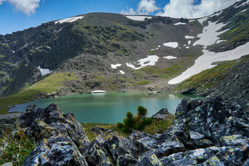 blue alpine lake formed from a glacier on top of a mountain