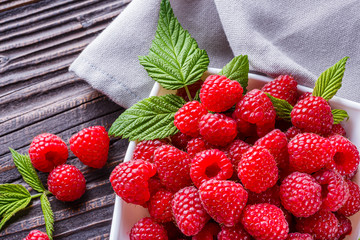 juicy fresh natural raspberries on a dark wooden rustic background