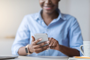 Online Payment. Smiling Black Woman Using Smartphone At Workplace In Office, Closeup