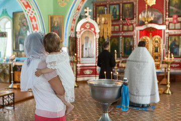 Godmother with goddaughter have ceremony of the Baptism of baby in the Orthodox church. People...