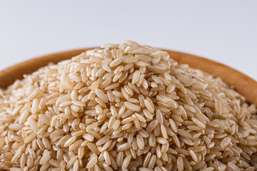 raw brown rice on white acrylic background