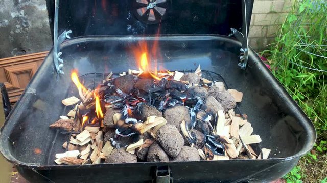 Natural mesquite wood barbecue smoking and flaming up for cooking. 