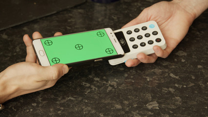 Contactless payment with a green screen smart phone in a cafe
