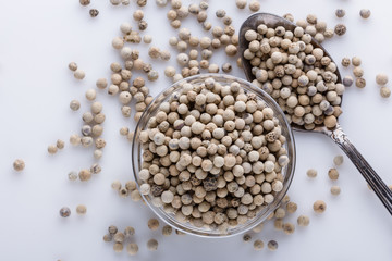 white peppercorns in glass bowl with spoon