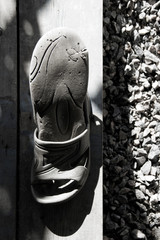 Photo of old slippers on the background of gravel.