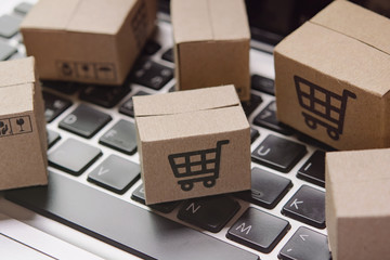 Shopping online. Cardboard box with a shopping cart logo on laptop keyboard. Shopping service on The online web. offers home delivery.