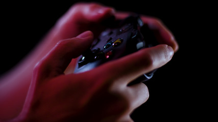 Playing video games close up with a black background