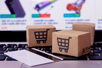  Shopping online. Credit card and cardboard box with a shopping cart logo on laptop keyboard. Shopping service on The online web. offers home delivery.