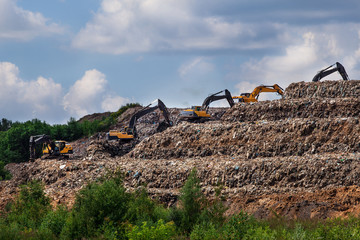 Garbage landfill in the Moscow region. Excavators level the garbage pile at the trash dump. Summer...