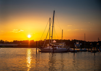 Sailboats at Sunrise at the marina on calm water in Beaufort North Carolina.