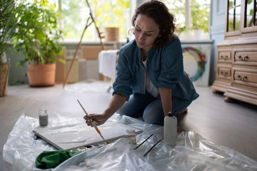 Female artist creating artwork on floor