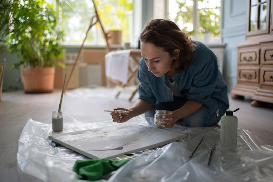 Adult woman painting on floor