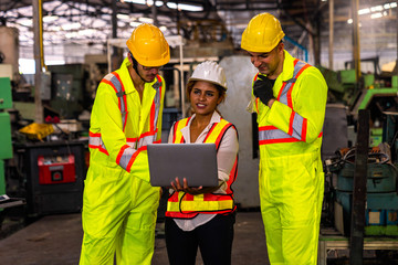 A technician is working in an industrial factory using a laptop computer.