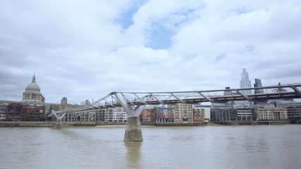 London Thames people walking over millennium bridge with st Paul's cathedral in the background