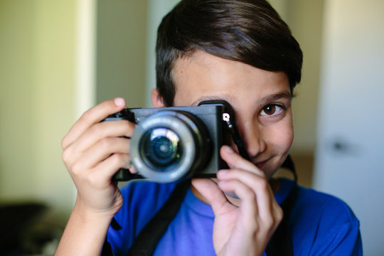 Portrait of a boy holding a camera up to his eye