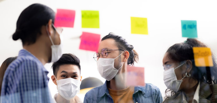 Interracial business team wear face mask brainstorm at new normal office Panorama