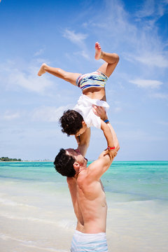 Father and son playing at a beach in the Caribbean.