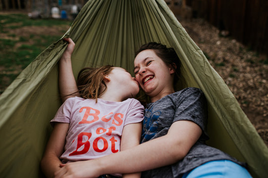 young girls goofing around in hammock outside