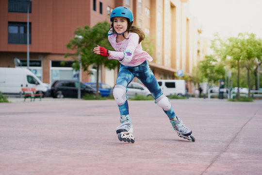 girl on the street skates with inline skates and helmet