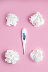 thermometer and crumpled handkerchiefs on a pink background