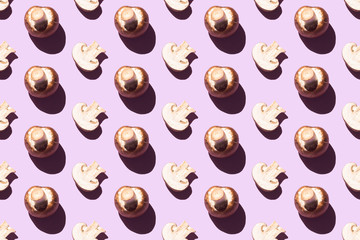 Seamless pattern of cut and whole champignons on a purple background