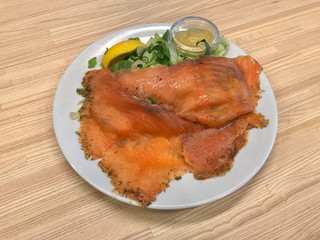 Smoked Salmon Gravlax Salad with Mustard Sauce in Plate Served with Tray at Restaurant. Healthy Fast Food.