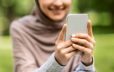 Closeup of modern smartphone in muslim woman hands