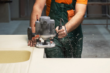 Stone sink furniture production. Carpenter polishes the surface of the sink with a grinder