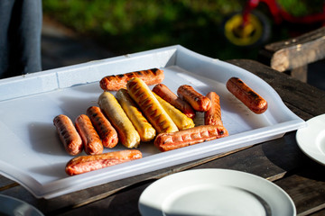 Fried juicy sausages on a white tray