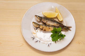 grilled sardines with lemon and parsley on the plate