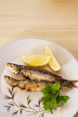 grilled sardines with lemon and parsley on the plate