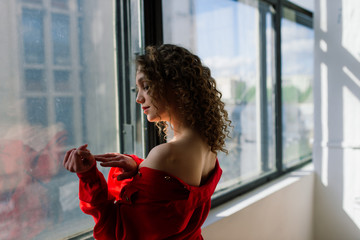 Unretouched portrait of a young natural beauty woman at home bedroom cozy rustic interior at vacation. Beautiful slim sexy lady in red male shirt and lace lingerie