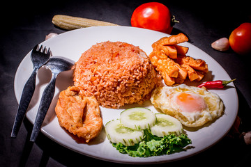 Fried rice with tomato sauce, garnished with sausage, fried chicken and egg