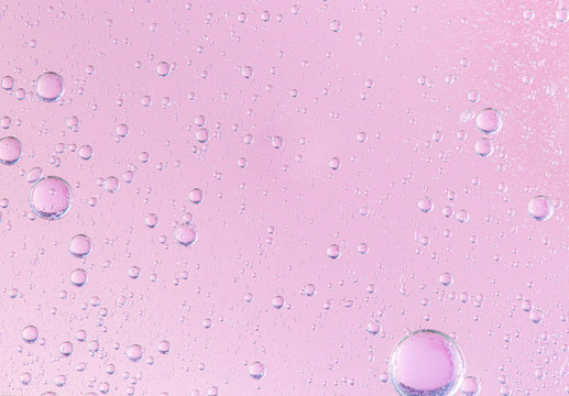 oil with bubbles on coral background. Pink Abstract space background. Soft selective focus. macro of oil drops on water surface. copy space. air bubbles in water,
