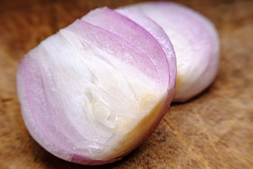 Close up sliced half of shallot on a wooden board background