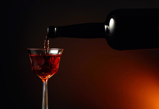 Aged golden fortified sherry being poured into a crystal glass.