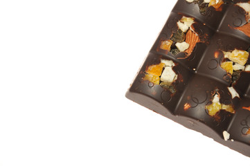 Bar of milk chocolate with raisins and dried apricots on a background of cinnamon sticks close-up